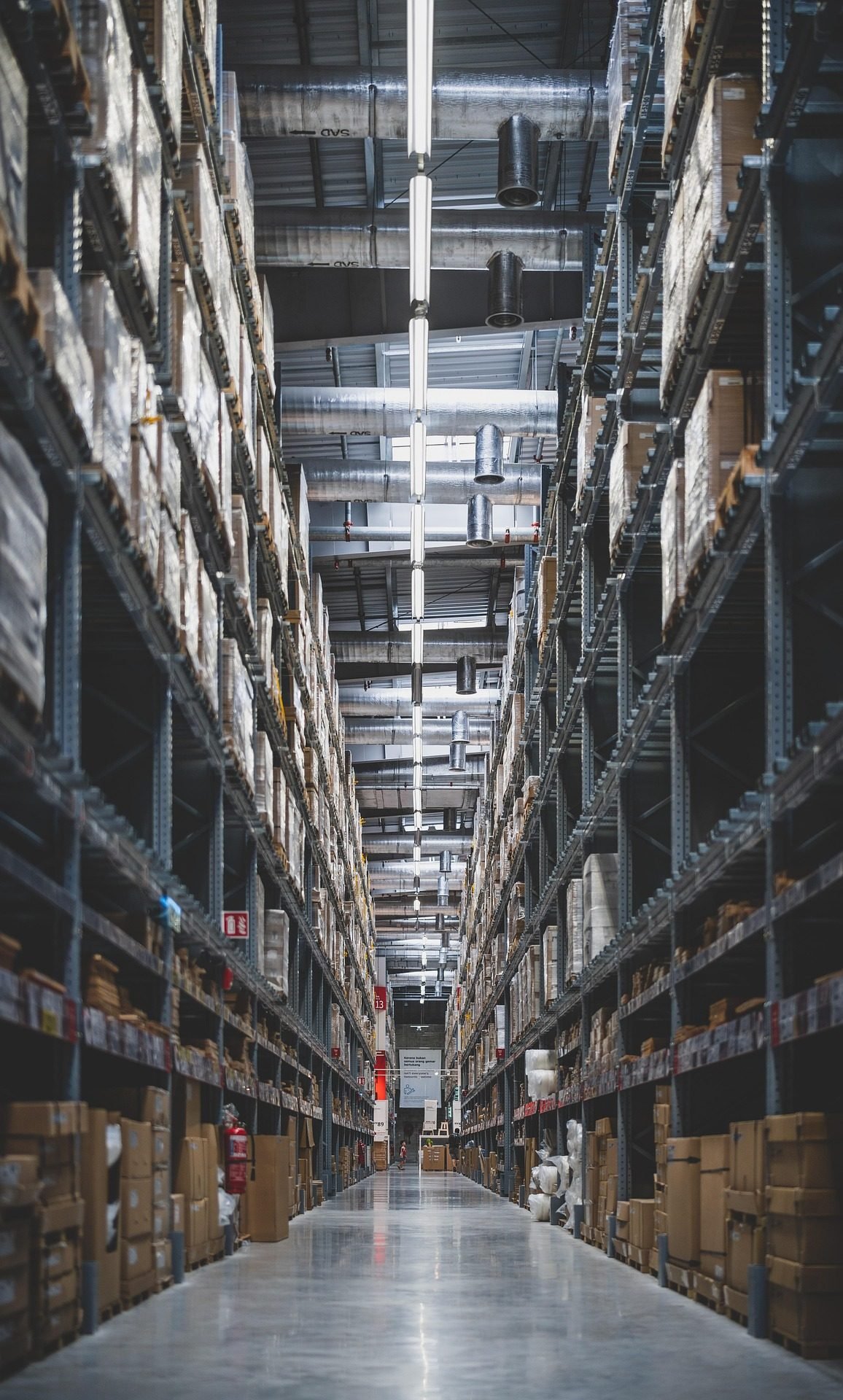 Allée d'un grand entrepôt logistique aux rayonnages remplis